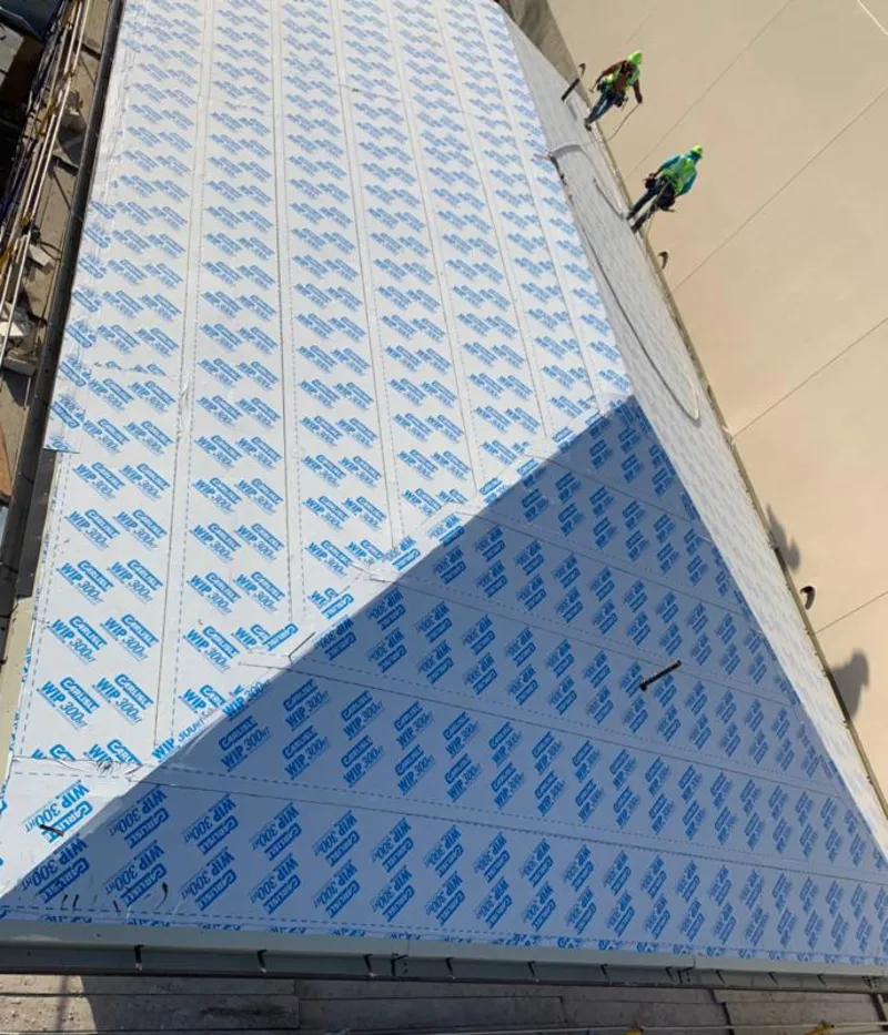 Professional roofers installing underlayment on a metal roof in Tunkhannock